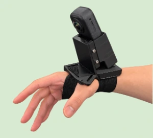 Camera module strapped to the wrist of a bare hand